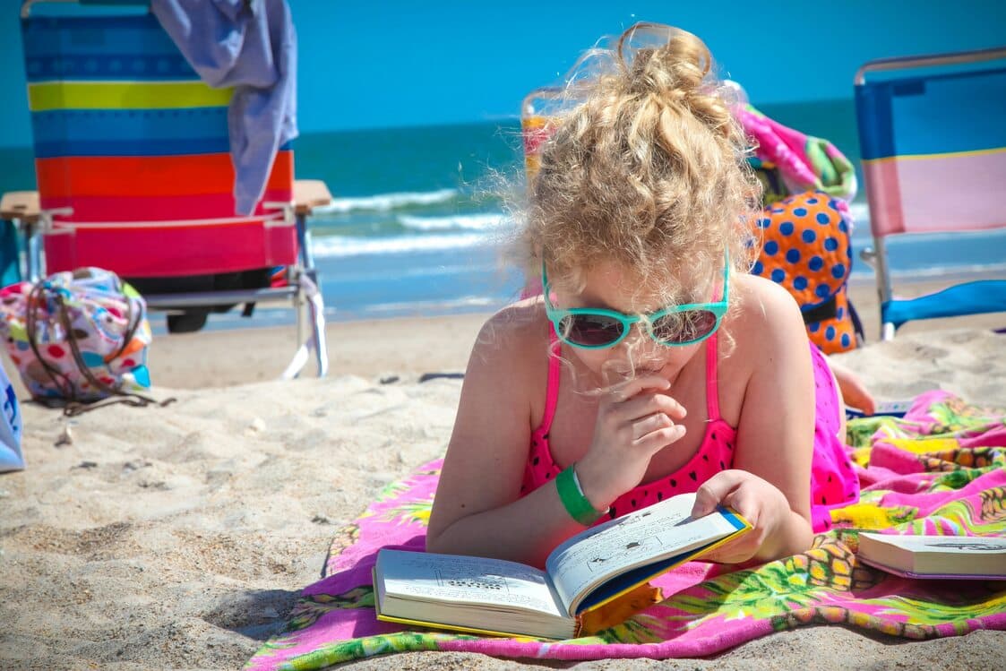 Child reading outside during summer
